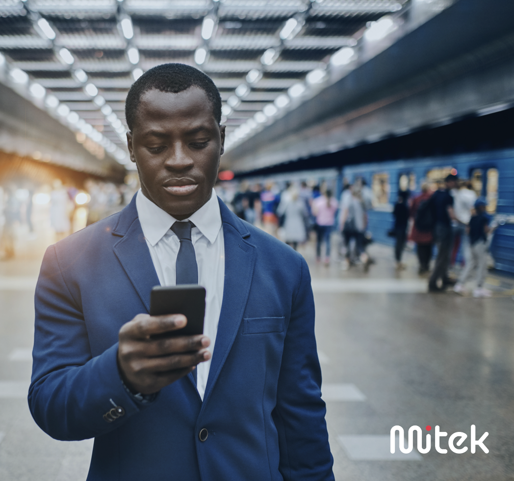 Man in train station on his mobile phone